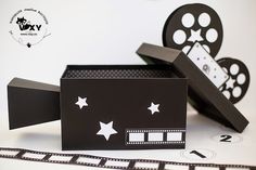 a black box with white stars on it sitting next to a movie reel and tape