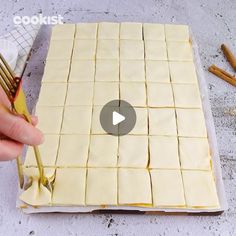 someone is cutting up some food on a sheet of paper with gold utensils