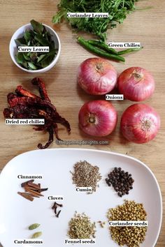 an assortment of spices and herbs on a white plate