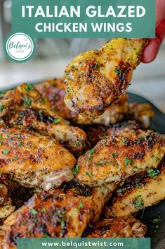 chicken wings being held up with the words italian glazed chicken wings above them on a black plate