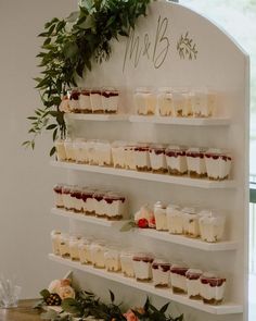 there are many desserts displayed on the wall in this room with greenery around it