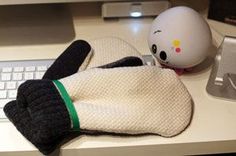 a hello kitty stuffed animal laying on top of a computer desk next to a keyboard