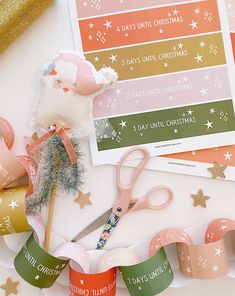 some pink and green christmas themed items on top of a white table with gold stars