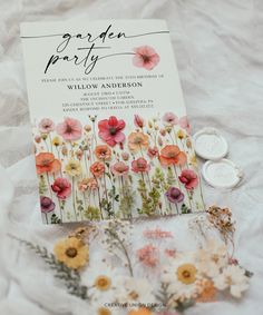 an open book with flowers on it next to two coins and a flower bouquet in the middle