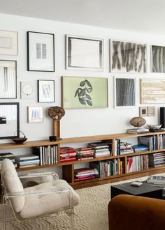 a living room filled with lots of furniture and pictures on the wall above it's bookshelf