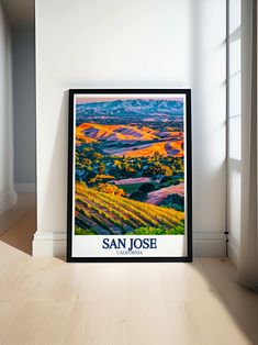 a framed poster is sitting on the floor in front of a white wall and window