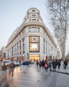 many people are walking around in front of a building