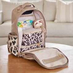 an animal print purse sitting on top of a wooden table next to a white couch