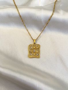 Made from tarnish-resistant stainless steel with a triple layer of 18k gold plating, this checkerboard necklace boasts a celestial motif for just the right amount of whimsy.  Not sure what to get that special someone in your life? Look no further, because this little cutie makes a great gift! P R O D U C T  *  D E T A I L S * 18k gold plated stainless steel * 19" long  * pendant measures 2 cm x 1.7 cm * handmade in Canada Want to keep this item in mind for later? Click on the heart symbol "Add i Gold Square Pendant Jewelry In Stainless Steel, Gold Stainless Steel Square Pendant Jewelry, Gold Square Pendant Stainless Steel Jewelry, Gold Celestial Jewelry With Rectangular Pendant, Celestial Gold Plated Pendant Necklace, Gold Celestial Charm Necklace In Brass, Celestial Style Charm Necklace With Adjustable Chain, Gold Plated, Celestial Yellow Gold Pendant Necklace, Heart Symbol