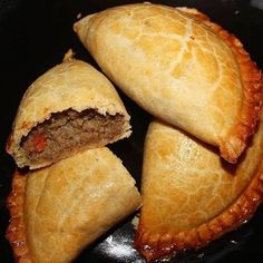 three pastries sitting on top of each other in a frying pan with meat inside