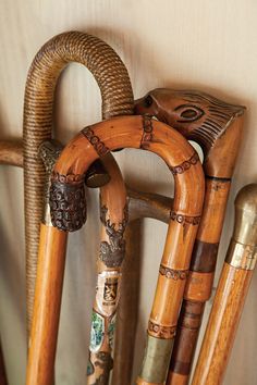 an assortment of wooden canes are arranged on the wall