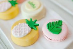 three decorated macaroons sitting on top of a white tray next to each other