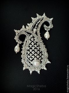 an ornate brooch with pearls on it