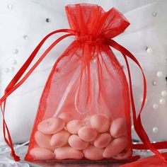 a red organ bag filled with white chocolates sitting on top of a table next to a pillow