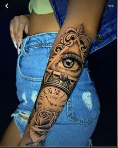 a woman's arm with an eye and clock tattoo on the side of her body