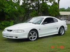 a white sports car parked in the grass