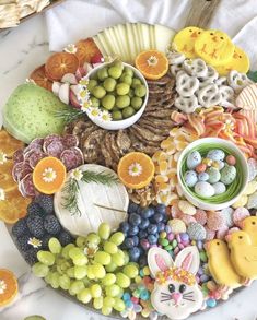 a platter filled with lots of different types of fruit and veggies on top of a table