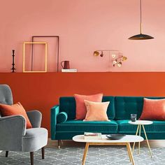 a living room with pink walls and blue couches in front of a coffee table