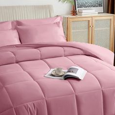 a pink comforter set on a bed in a bedroom