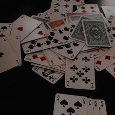 a pile of playing cards sitting on top of a black table next to each other