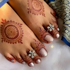 the feet are decorated with henna and flowers on them, while one foot is adorned with jewels