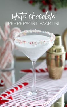 a white chocolate peppermint martini in a coupe glass with candy canes on the side