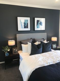 a bedroom with two pictures on the wall above the bed, and one is black and white