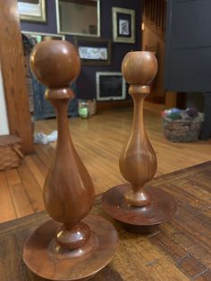 two wooden candlesticks sitting on top of a wooden table in a living room