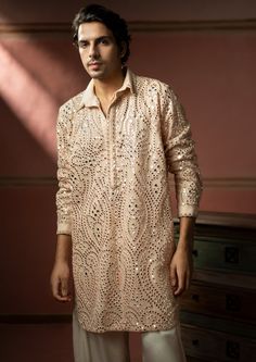 The georgette mirrorwork fabric is specially designed by our team and crafted with great care and precision. With the floating mirror effect of jaali-work, the garment is then styled at our workshop with finest details. Elegant Peach Kurta With Chikankari Embroidery, Elegant Peach Kurta With Zari Work, Designer Peach Kurta With Chikankari Embroidery, Peach Traditional Wear With Mirror Work, Peach Traditional Wear With Mirror Work For Festive Season, Peach Traditional Wear With Mirror Work For Diwali, Festive Peach Traditional Wear With Mirror Work, Festive Traditional Wear In Peach With Mirror Work, Floating Mirror