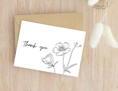 a thank you card with black ink on white paper, featuring two flowers and the words thank you