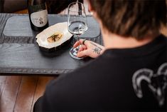 a person sitting at a table with two wine glasses