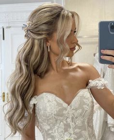 a woman is taking a selfie in her wedding dress while she holds up her phone