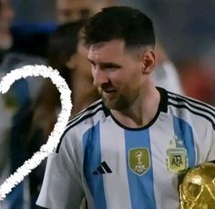 a man holding a soccer ball in his right hand and wearing a blue and white uniform