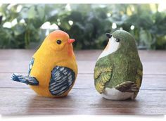 two small birds sitting next to each other on a table