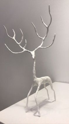 a white sculpture of a deer standing on top of a table