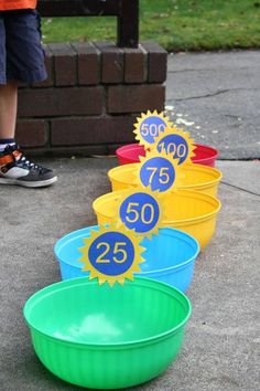 four buckets with numbers on them sitting in front of a brick wall and grass