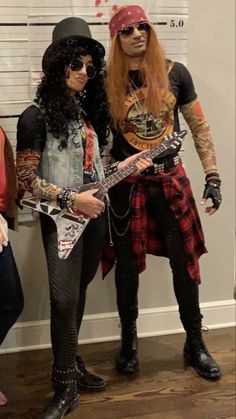 two people are dressed up as rockers and guitar players, one is holding an electric guitar