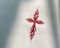 a cross drawn on the back of a white shirt with red ink and some other designs