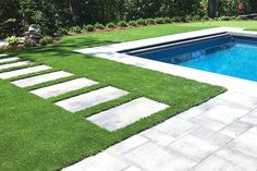 a swimming pool surrounded by grass and stepping steps