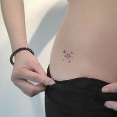 a woman's stomach with a small tattoo on it