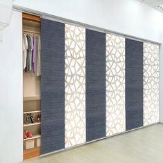 an open closet with sliding doors and clothes hanging on the shelves in front of it