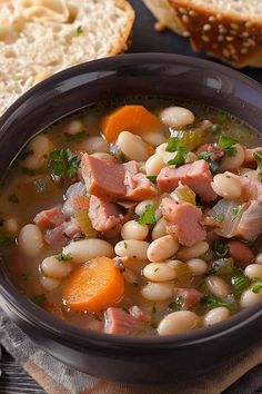 a bowl of ham and bean soup with bread on the side