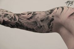 a man's arm with a bird and flowers tattoo design on the upper half