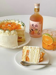 there are two pieces of cake on the table with oranges and a bottle of alcohol