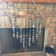 a fire place with a wooden sign hanging from it's side next to a metal bucket