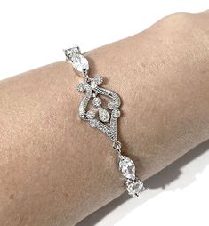 "Bridgerton bridal bracelet featuring Victorian wedding Regency vintage style glam cz motifs made of sparkly clear cubic zirconia in tarnish-resistant silver rhodium plated base. Bracelet length can be made to fit wrist size from 6\" (15cm) and 7\" (18cm). See menu for your own preferred length. We will give a little allowance for your wrist adjustment. Bracelet cz part length is at 4 3/4\" (12cm) and secures with a lobster claw. Width is 1/2\" (1.2cm) at its widest. View matching pieces or simi Classic Wedding Tennis Bracelet With Sparkling Stones, Classic Cubic Zirconia Crystal Bracelet For Wedding, Classic Crystal Bracelets For Wedding, Elegant Diamond Crystal Bracelet For Wedding, Elegant Silver Diamond Bracelet With Intricate Design, Elegant Cubic Zirconia Wedding Bracelets, Classic Diamond Crystal Bracelet For Wedding, Elegant Crystal Tennis Bracelet For Wedding, Elegant Crystal Bracelets For Wedding