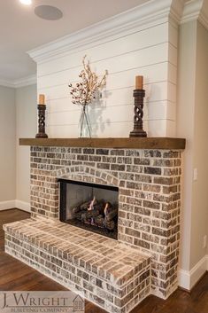 a brick fireplace with two candles on top