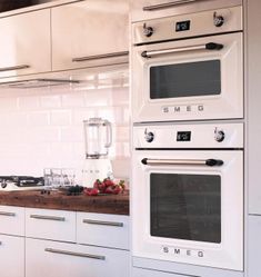 a kitchen with two ovens and a blender on the counter next to it