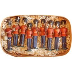 an assortment of wooden toy soldiers in a box