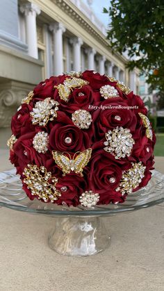 a bridal bouquet is sitting on a glass platter in front of a building